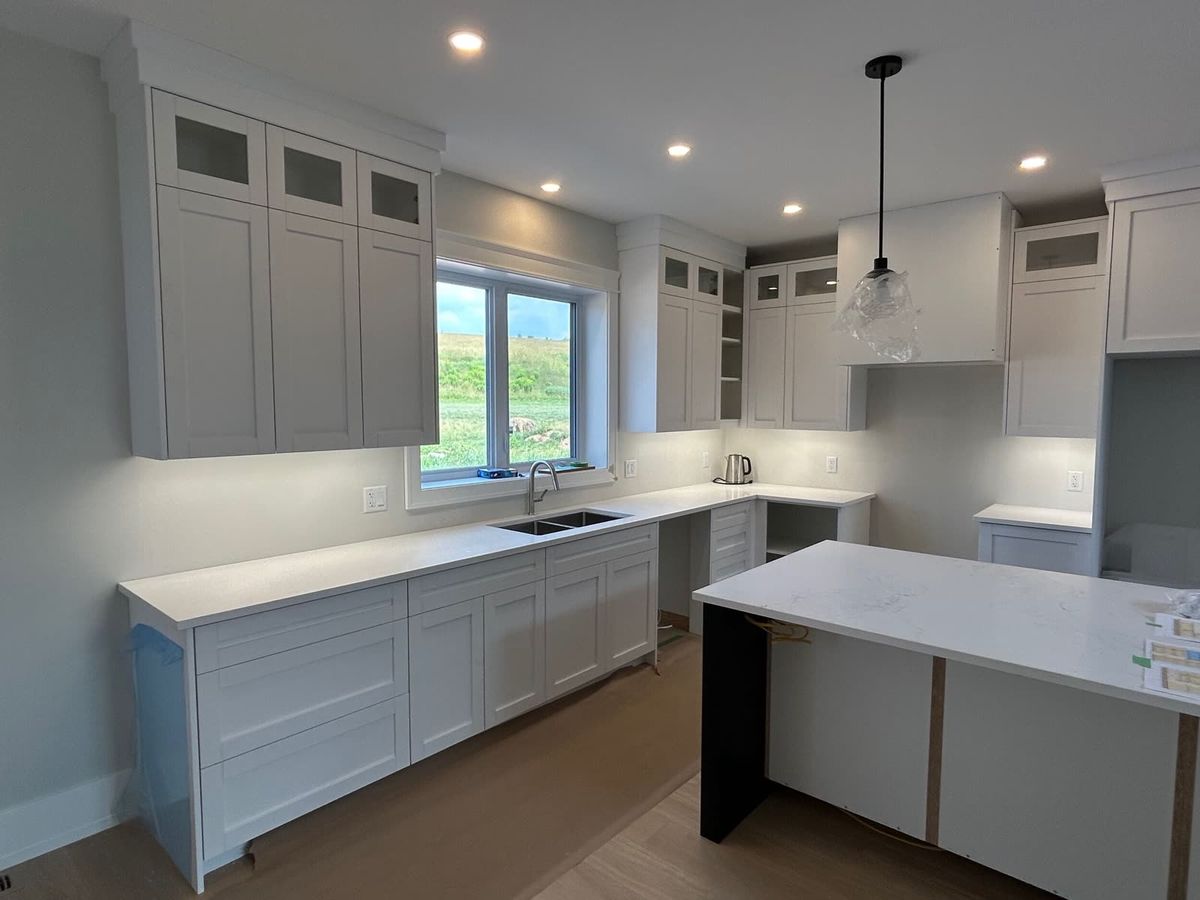 Finished white kitchen cabinetry built by Creek Ocean Construction